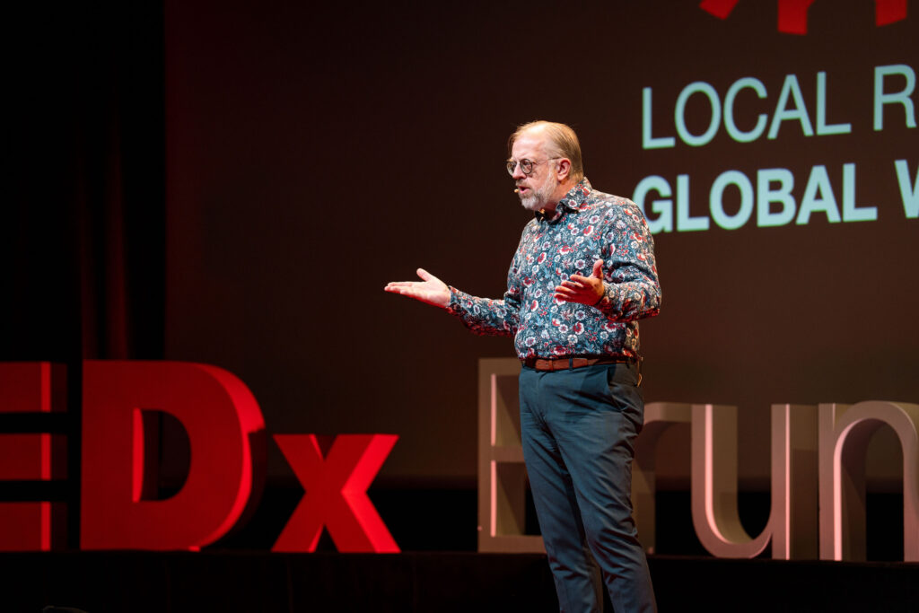 Markus Ertel spricht vor dem LOCAL ROOTS GLOBAL WINGS-Motiv
