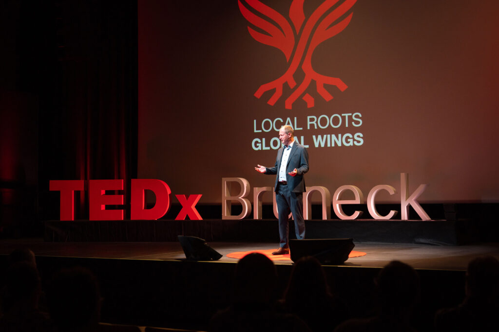 Joachim Goller auf der Bühne vor dem TEDxBruneck-Schriftzug