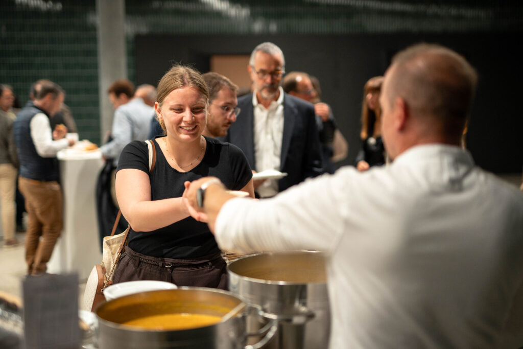 Eine Besucherin bekommt in der Pause Essen an der Ausgabetheke