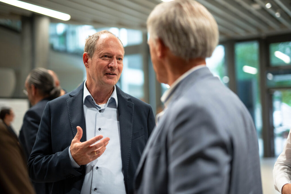 Zwei Gäste lachen bei einem Gespräch im Foyer