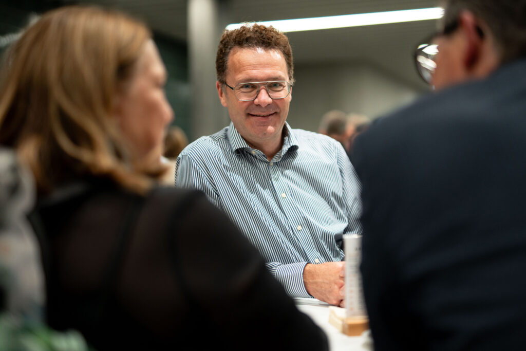 Ein Gast im gestreiften Hemd spricht im Foyer