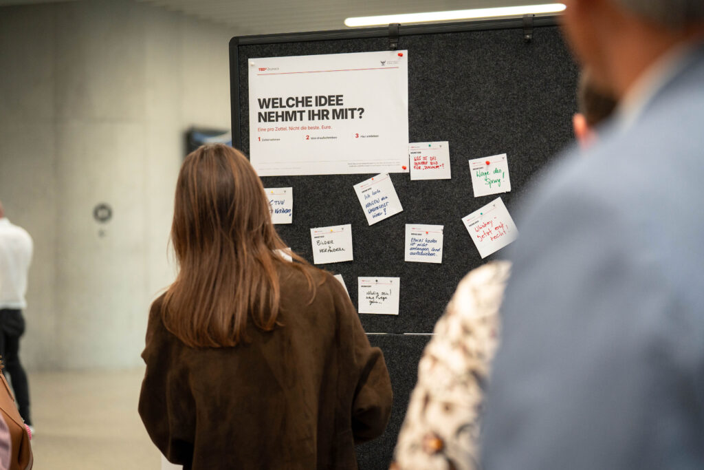 Besucherinnen betrachten die Ideenwand nach den Talks